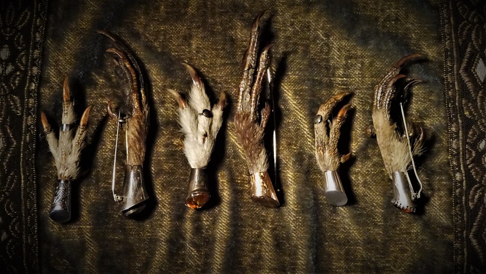 Six grouse claw or foot kilt pins in a row showing the different style and types.