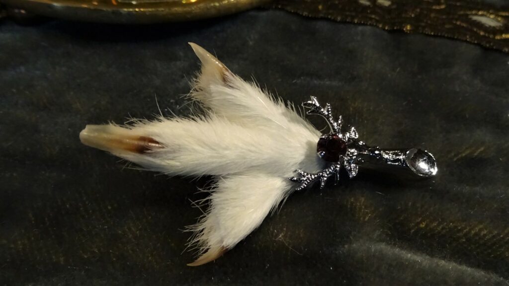 A newer grouse claw brooch with  a white fluffy appearance